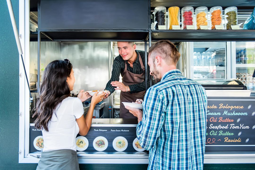 Customers collecting food at a busy takeaway counter
